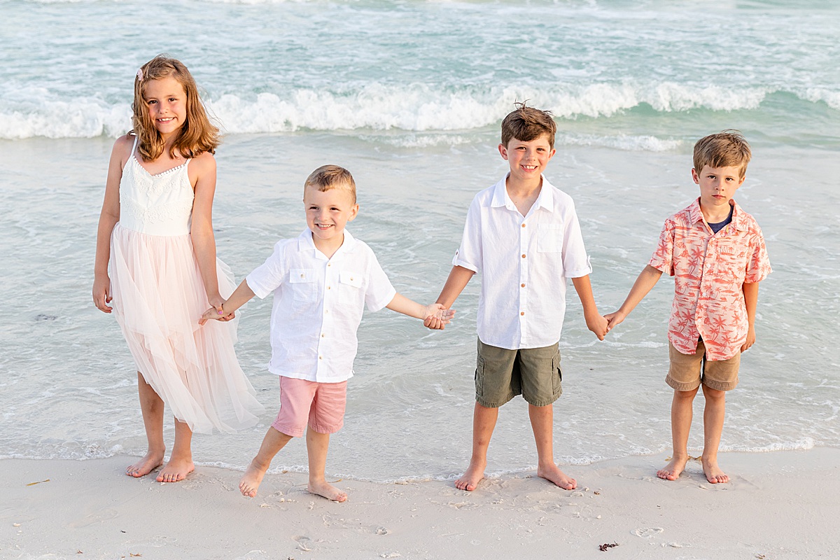 Kids holding hands on the beach by the water | Pensacola Beach extended family session by Pensacola Florida photographer Hannah Hillis Photography