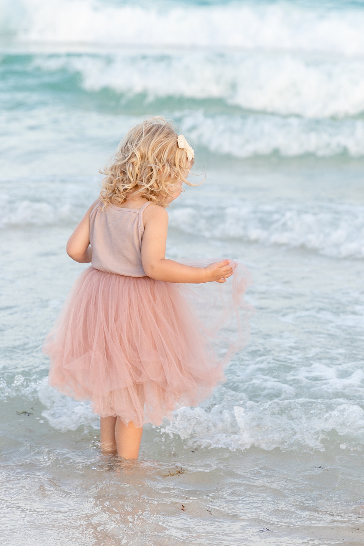 Little girl in a pink dress by in the ocean | Pensacola Beach extended family session by Pensacola Florida photographer Hannah Hillis Photography