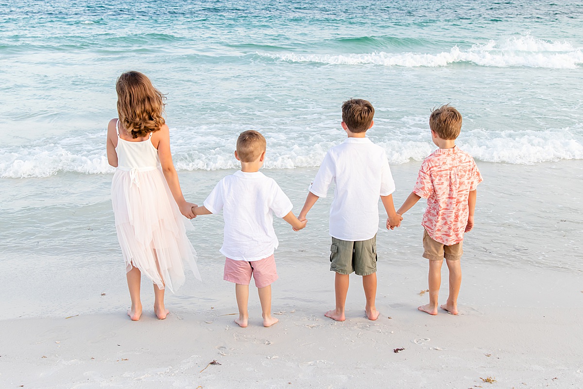 Kids holding hands on the beach by the water | Pensacola Beach extended family session by Pensacola Florida photographer Hannah Hillis Photography