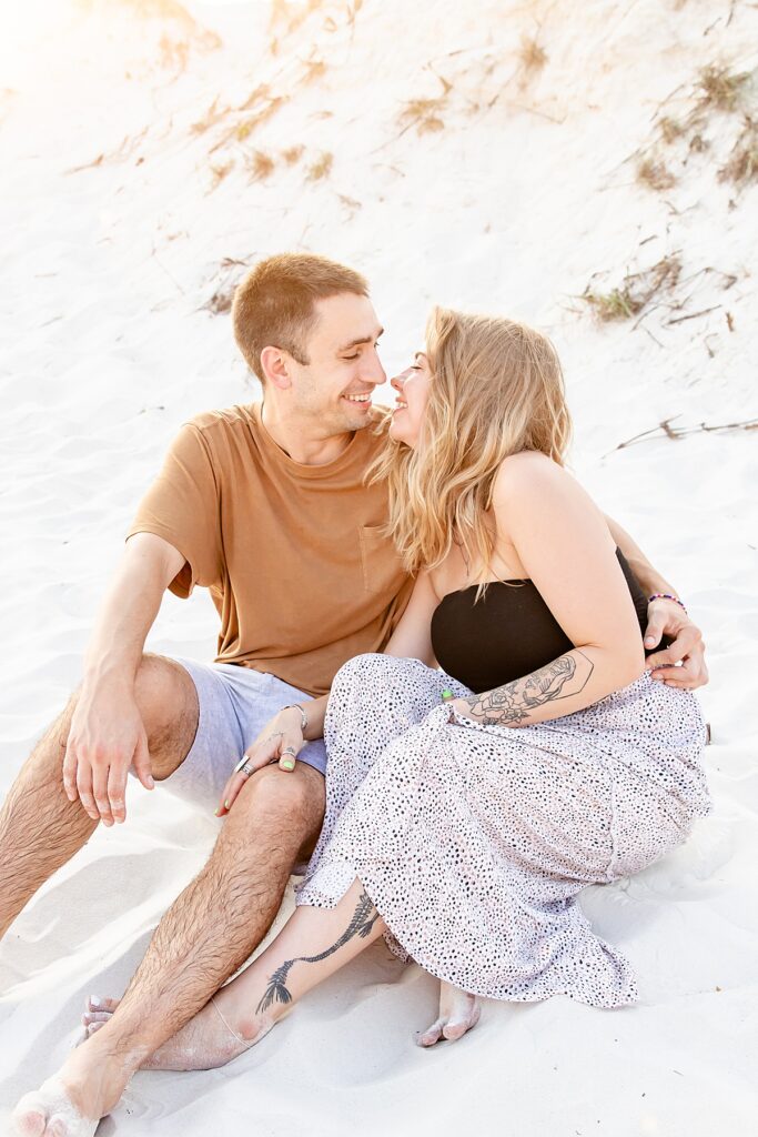 cute couple sitting in the sand during extended family session