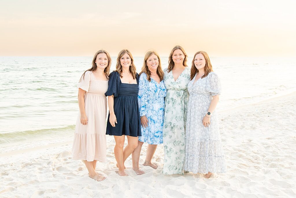 family posing by the water during extended family session on pensacola beach