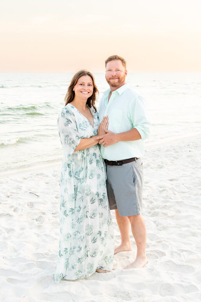 couple by the water on Pensacola Beach during extended family session