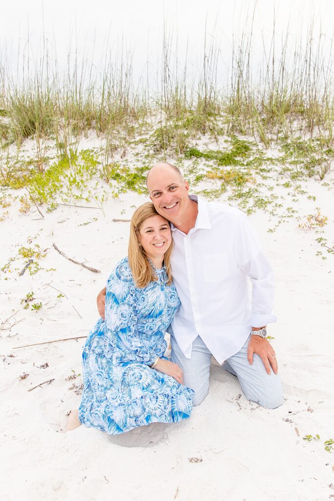 couple sitting in the sand during session on pensacola beach