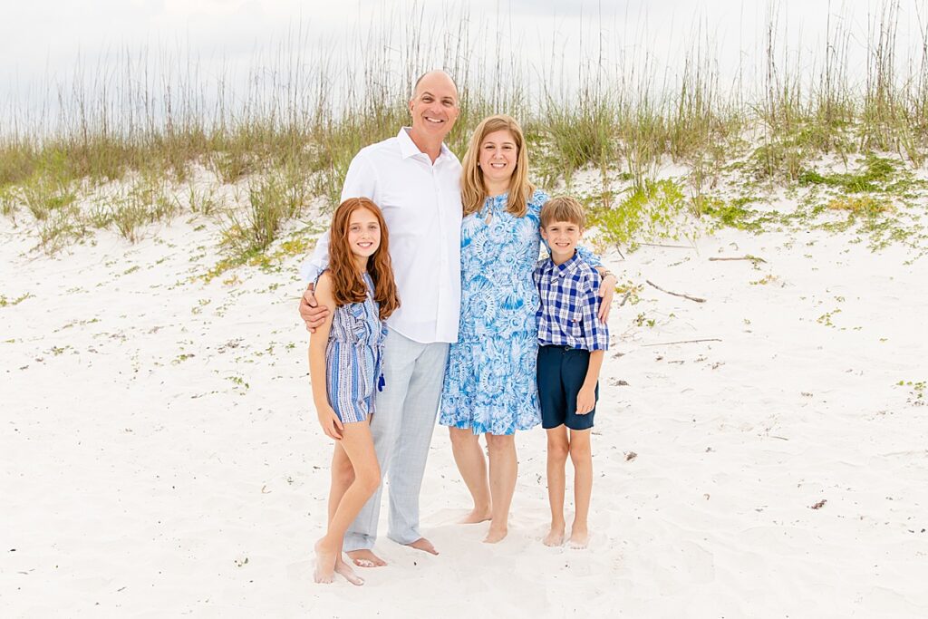 family posing on the beach during a family session on pensacola beach
