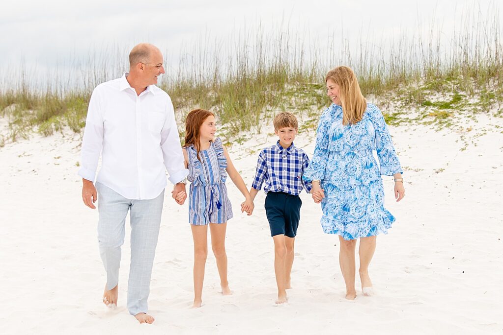 family walking and looking at each other during family session on pensacola beach