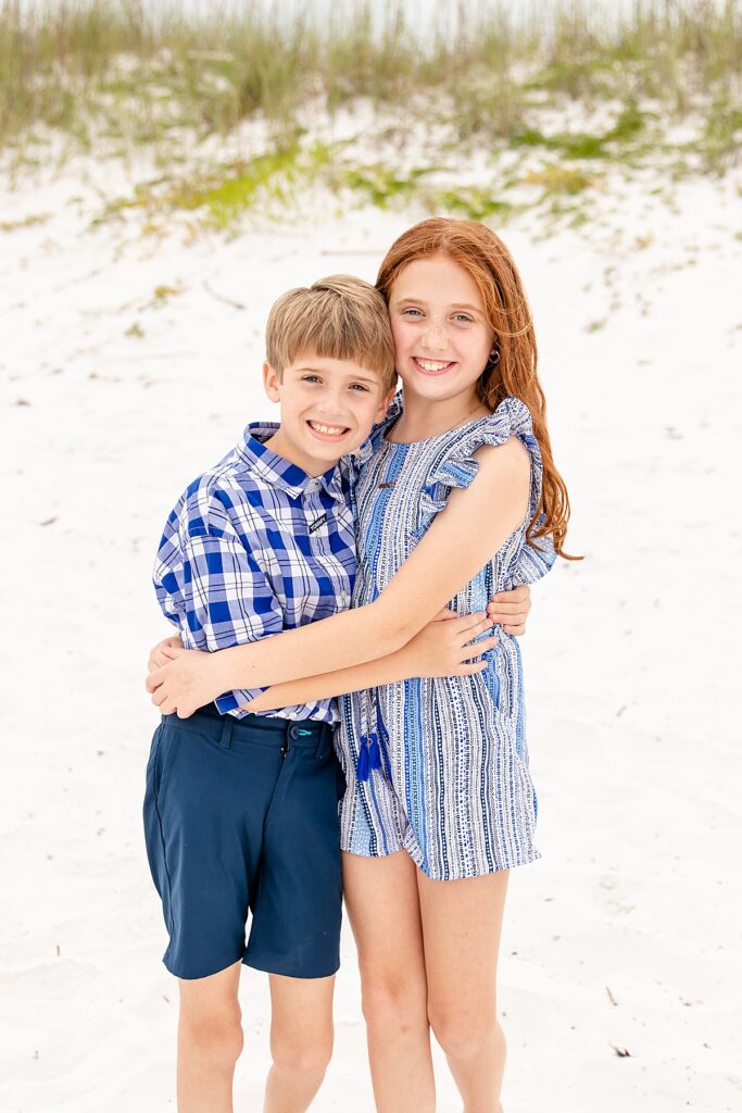 sister and brother hugging during family session on pensacola beach