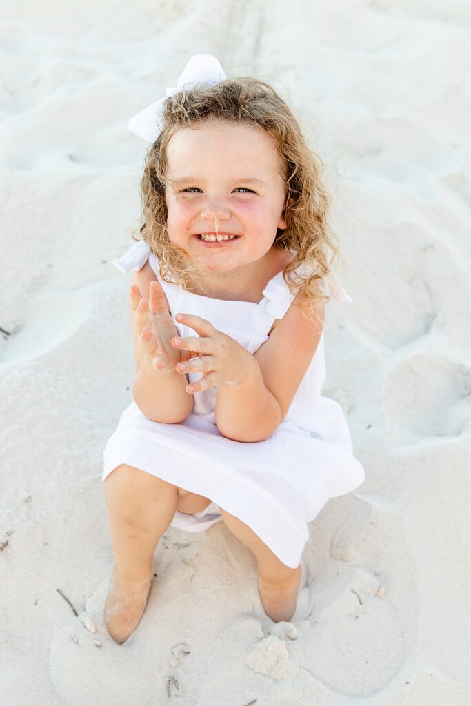 Little girl smiling in the sand